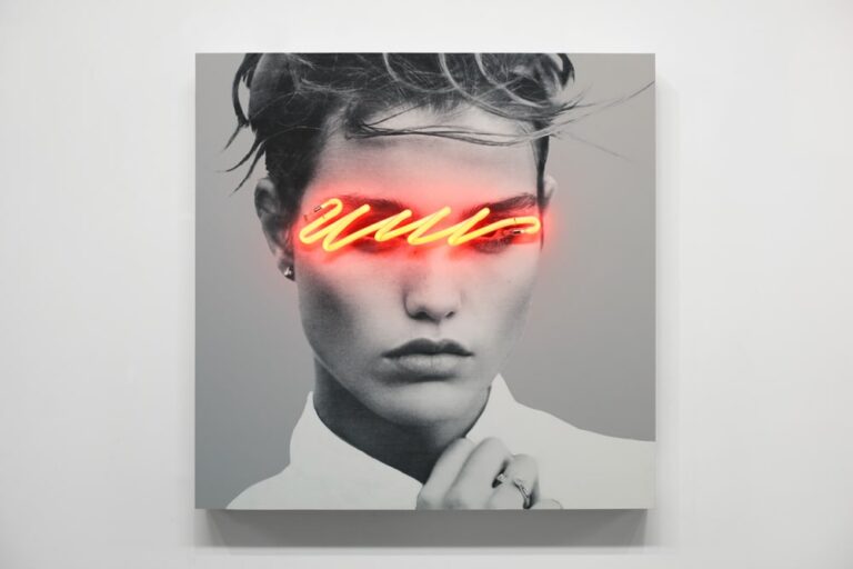 Interview with Javier Martin Neon art installation of a woman's face with glowing yellow-red eyebrows, black and white photo, modern artistic portrait.