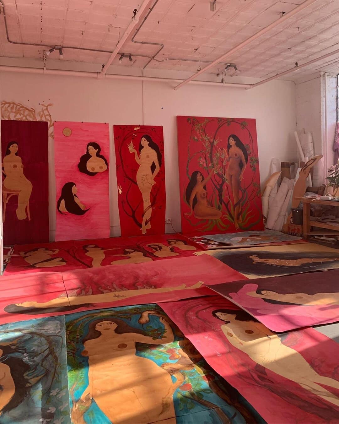 Vibrant female figure paintings displayed in an art studio setting for creative use.
