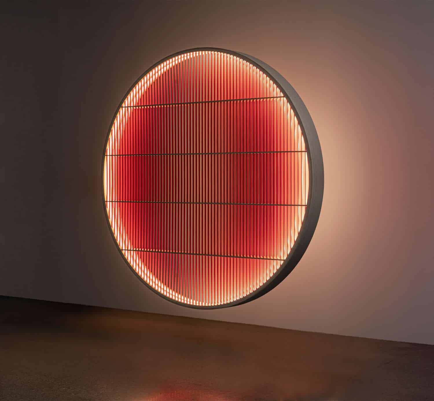 Illuminated circular wall art with red LED lights and modern geometric design.
