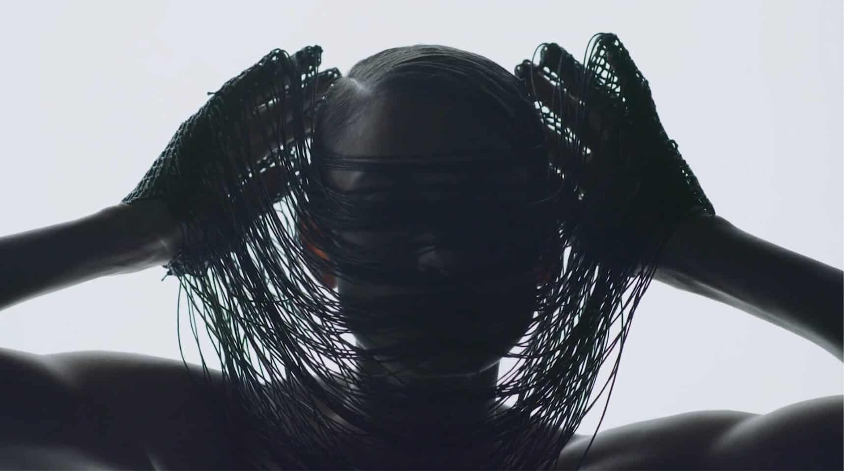Shiny black hair with a netted headpiece, artistic fashion photography.