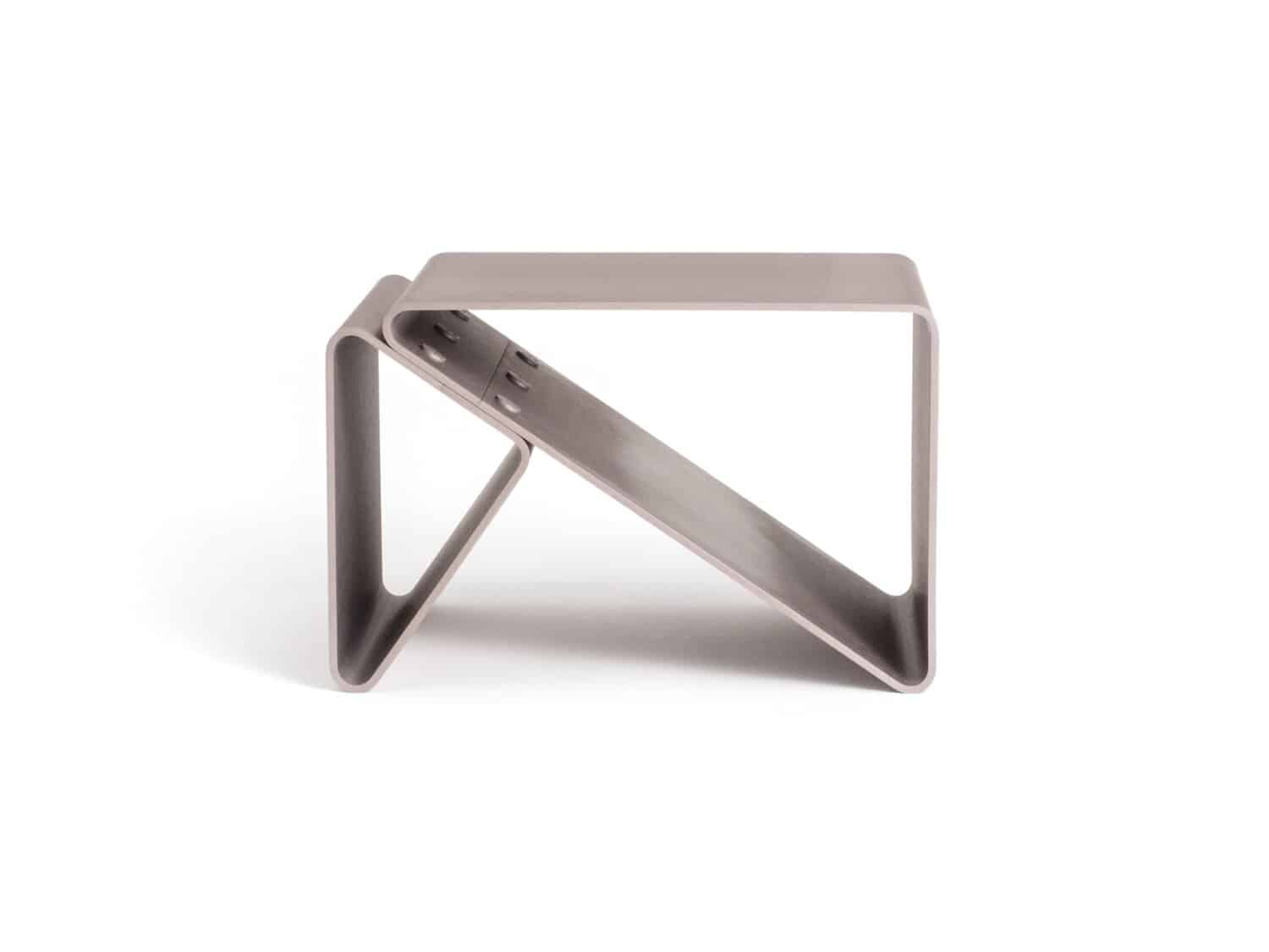 Modern minimalist metal magazine or book holder in metallic finish.