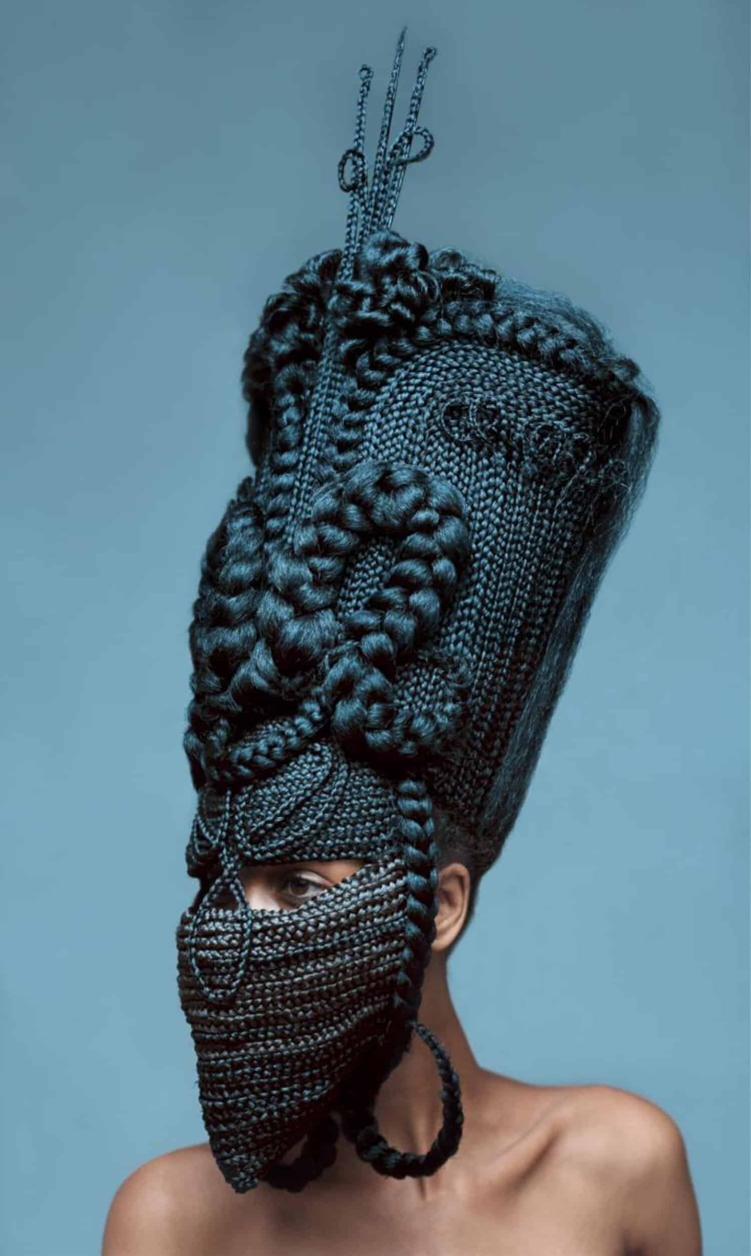 Intricate black braided headpiece and face mask with elaborate beadwork and textile details.