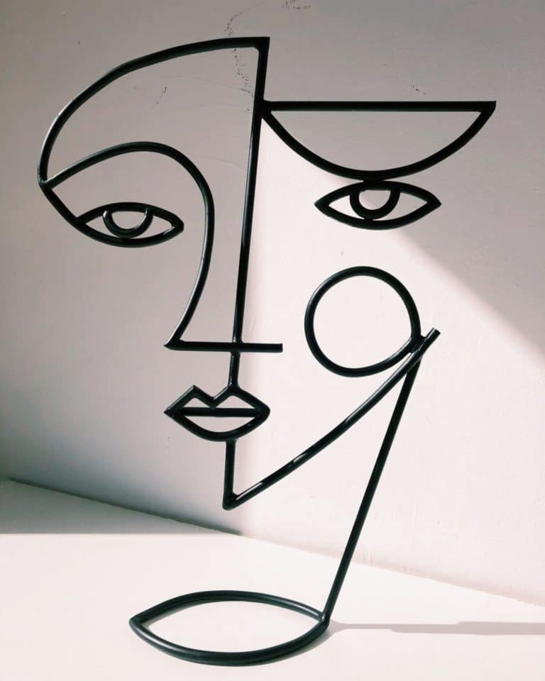 Diego Cabezas Creates Hand-Iron Forged Sculptures Contemporary abstract metal wall art featuring a minimalist face design with geometric lines and open shapes.