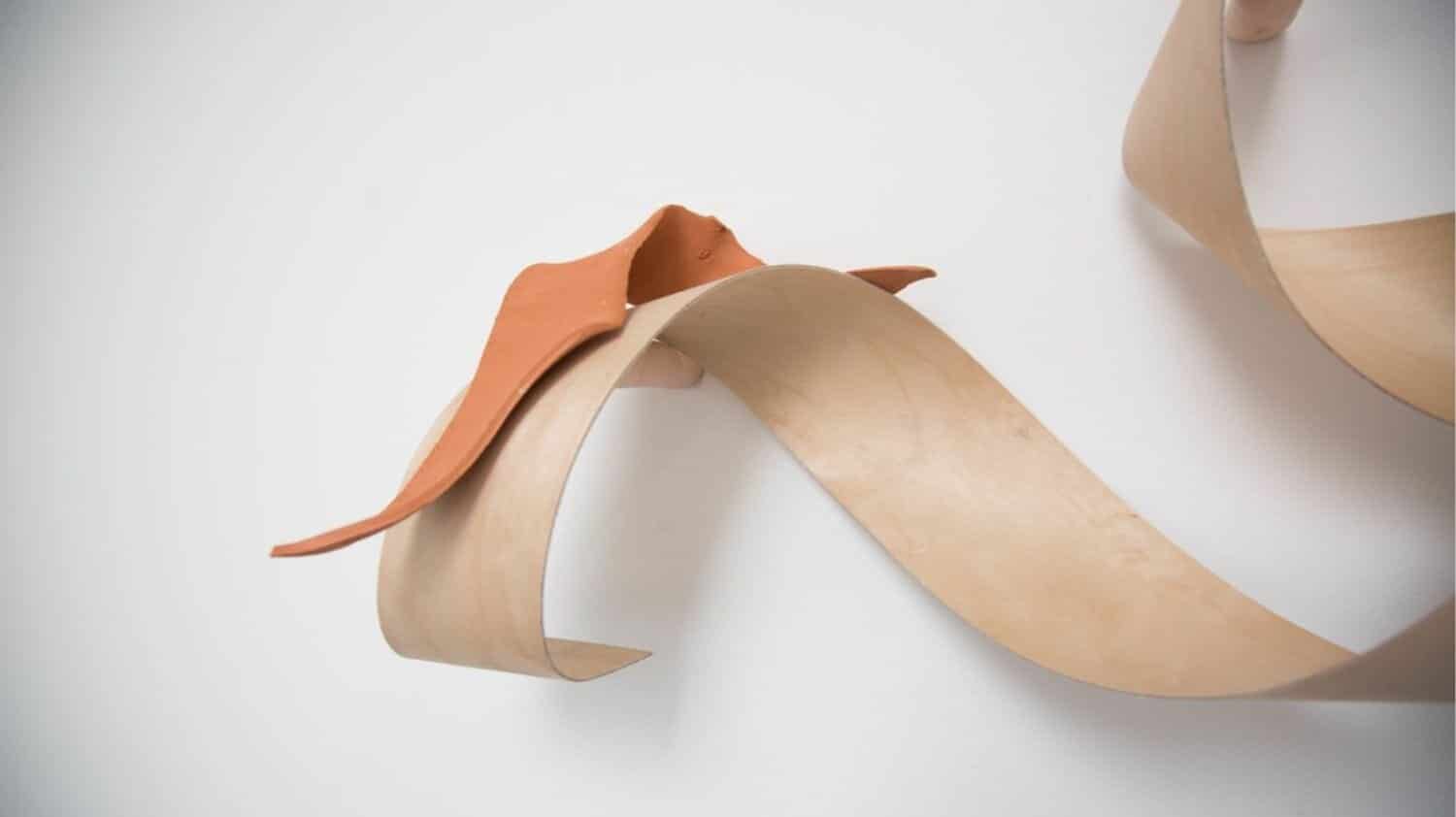 Sculptural wooden and clay art piece, contemporary abstract wall decor, minimalistic home interior sculpture.