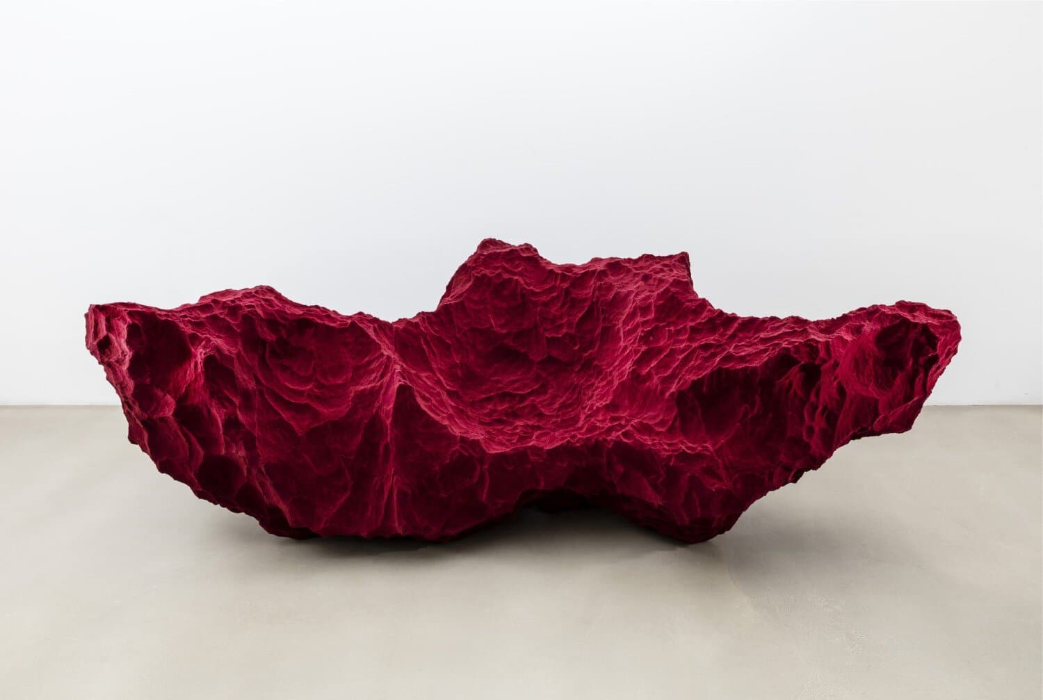 Vibrant red textured abstract sculpture on white background, contemporary art piece for modern gallery display.