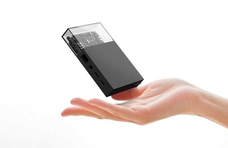 Mini portable speaker with transparent top showcasing internal components.