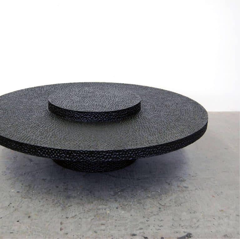 John Eric Byers Transforms The Wooden Maple Surface Elegant black textured ceramic coffee table with circular layered design.