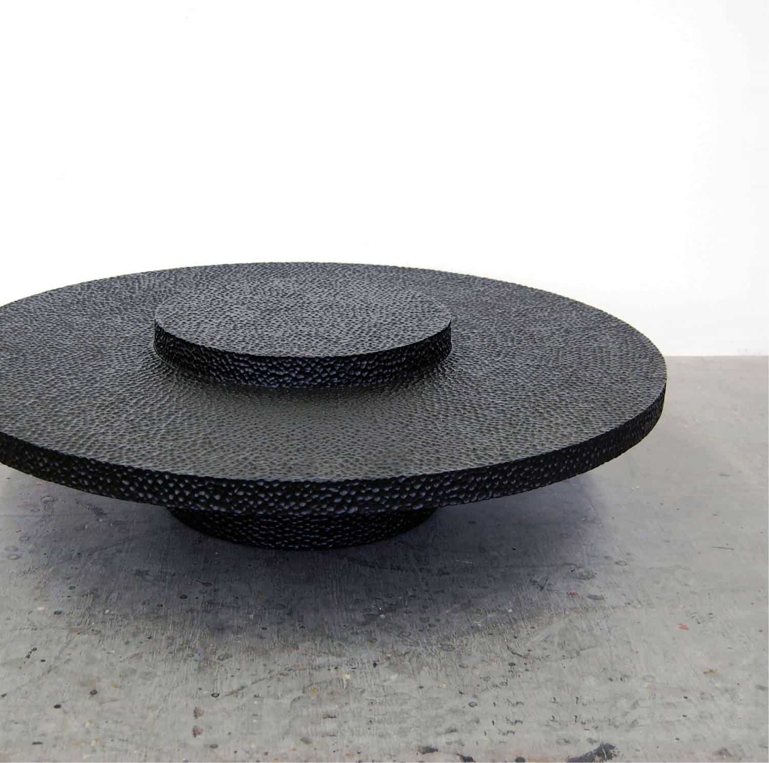 Elegant black textured ceramic coffee table with circular layered design.