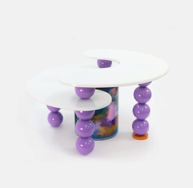 KAYA Combines Different Approaches In Creating New Decon Series Colorful modern art table with white and purple accents, unique design, and playful spherical legs.