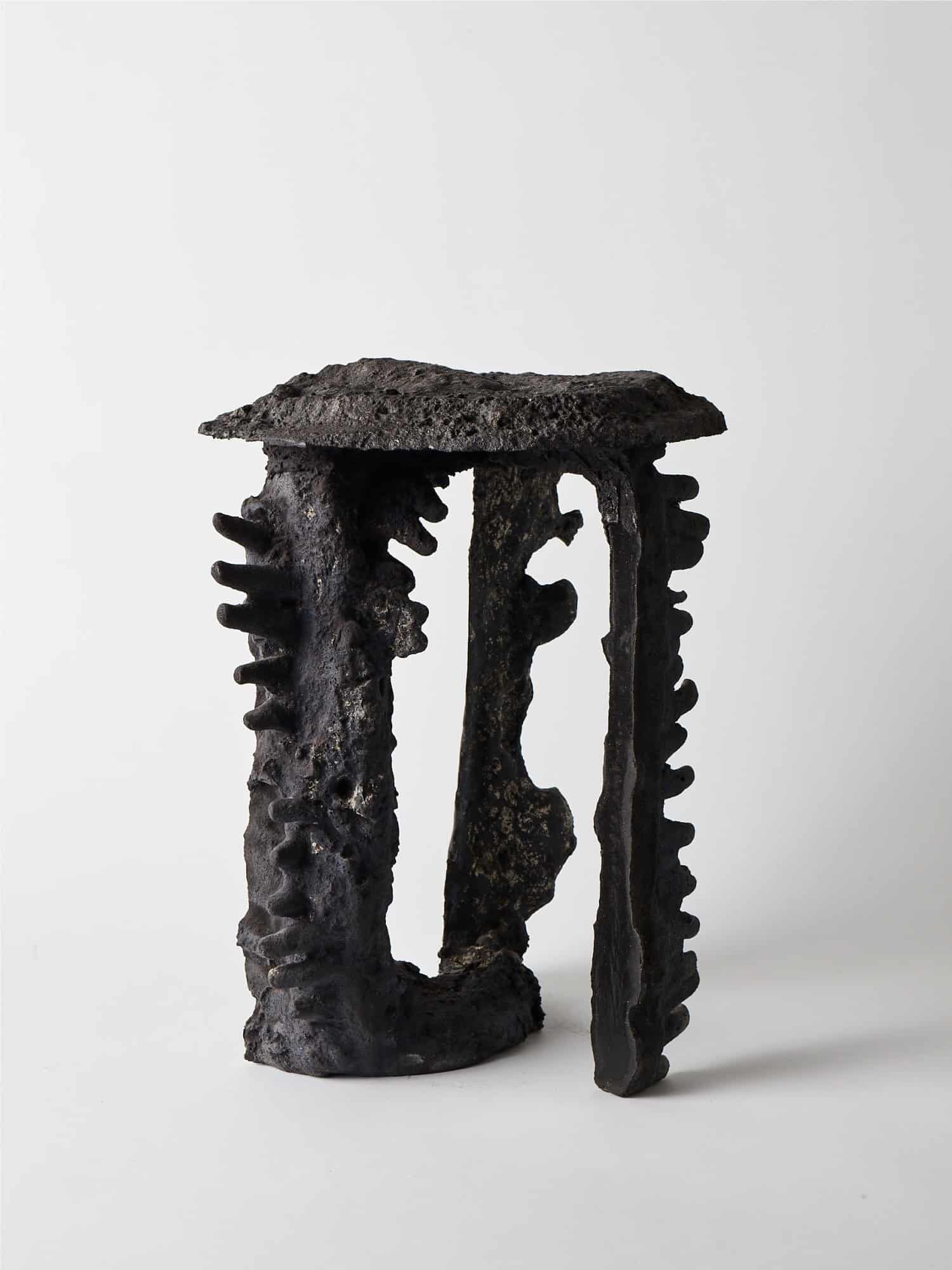 Rustic black cast iron decorative sculpture with textured surface and unique design.