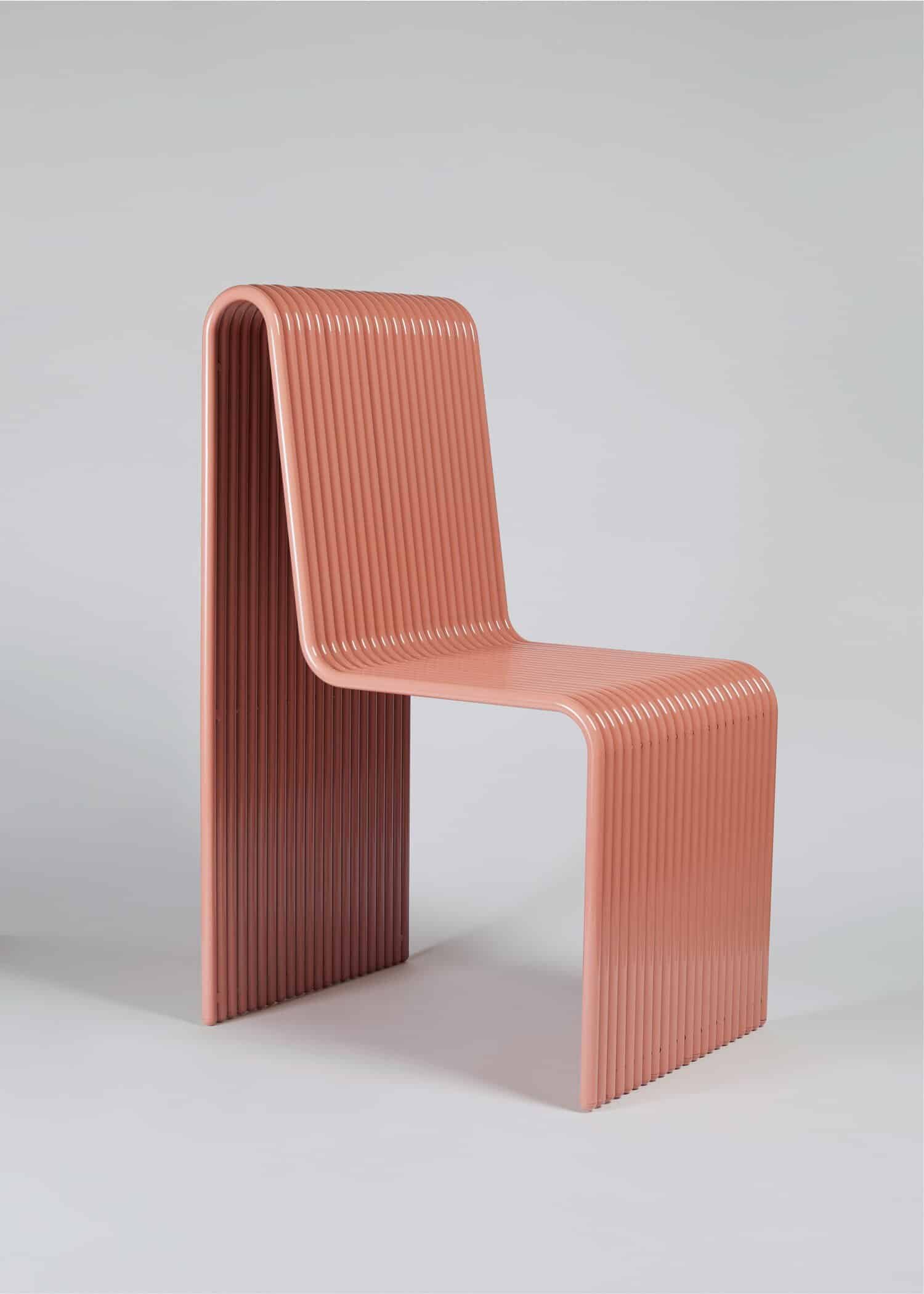Sleek modern pink ribbed chair with curved design, stylish and contemporary furniture piece.