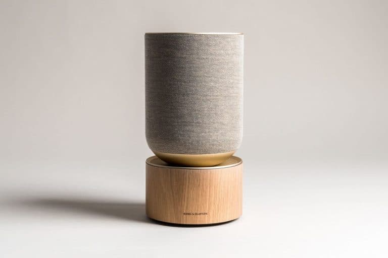 Elegant smart speaker with wooden base and fabric exterior for modern home decor.