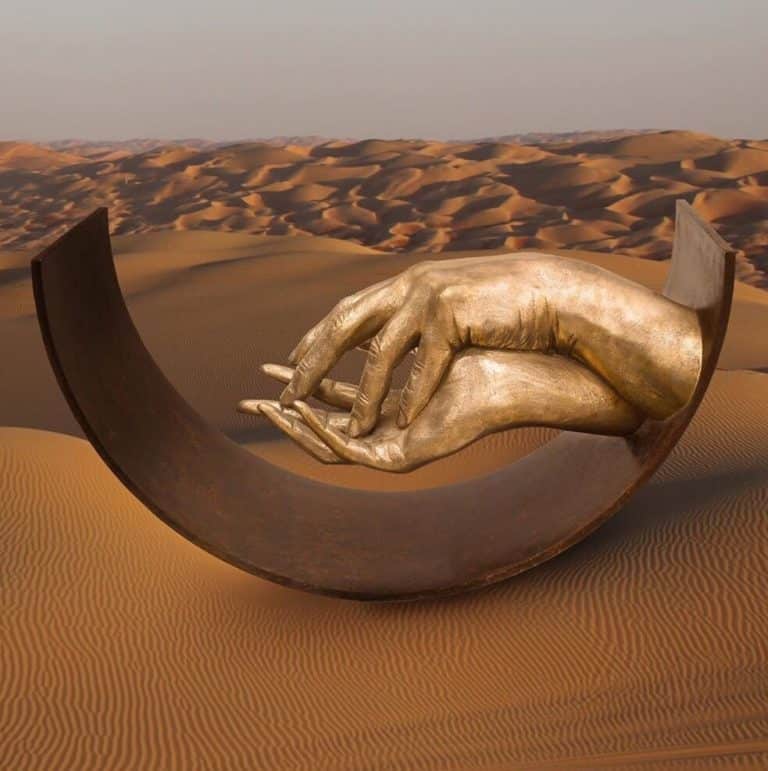 Lorenzo Quinn Tells The Message Of Love Through Giant Human Hands Hand sculpture in desert representing artistic expression and creativity.