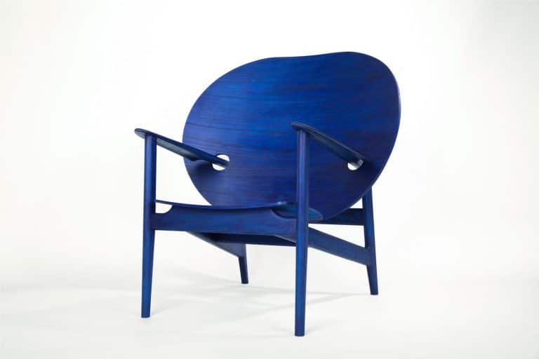 Mac Collins Invites To Explore Iklwa's Hidden Forms Vivid blue wooden armchair with modern design on white background.