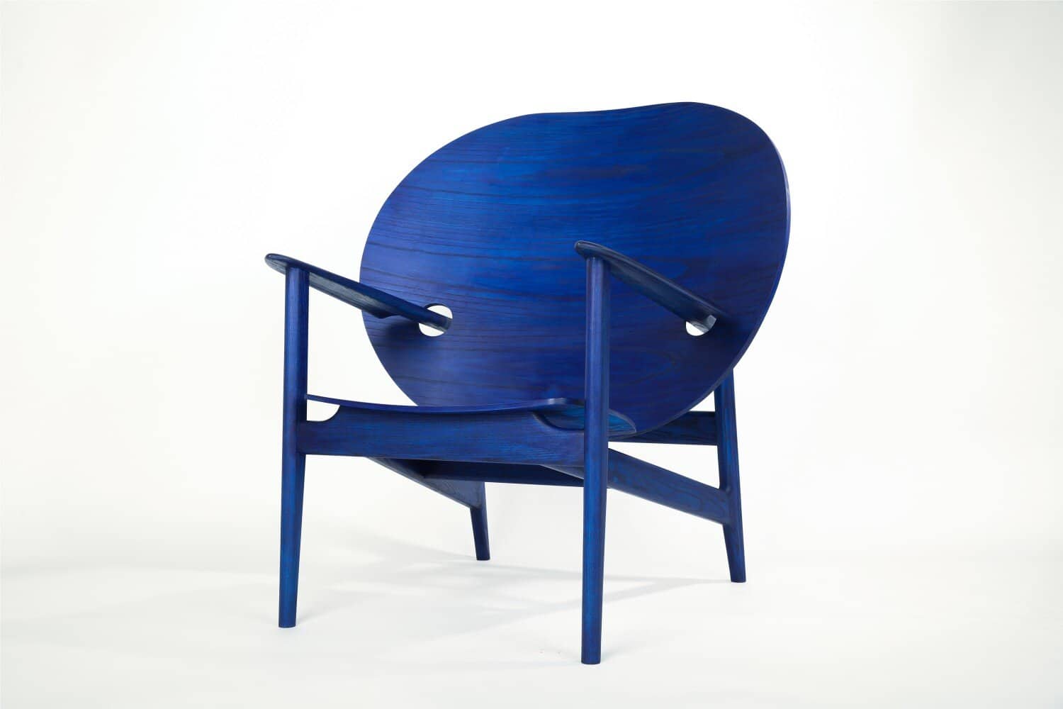Vivid blue wooden armchair with modern design on white background.