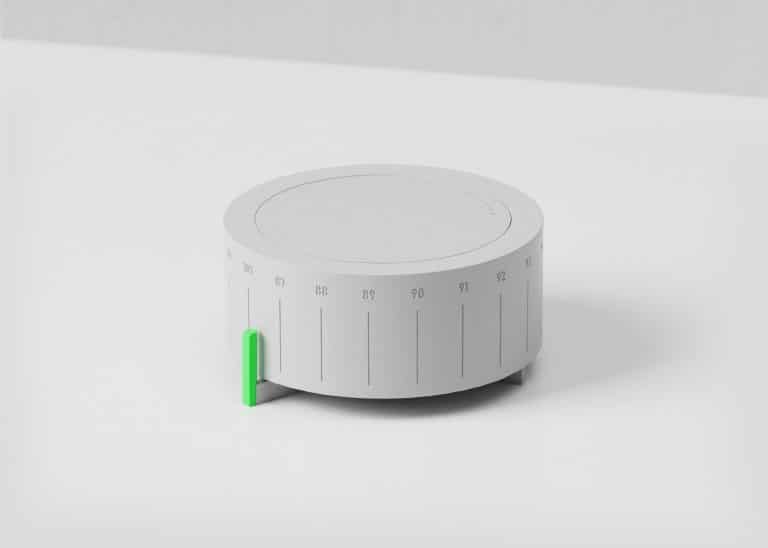 Timer with green button on a white surface, minimalist design.