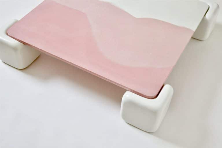Studio Mignone Alludes To Its Family Heritage And The Visual Quality Pastel pink drawing tablet on white stand, minimalist art supplies for creative work.