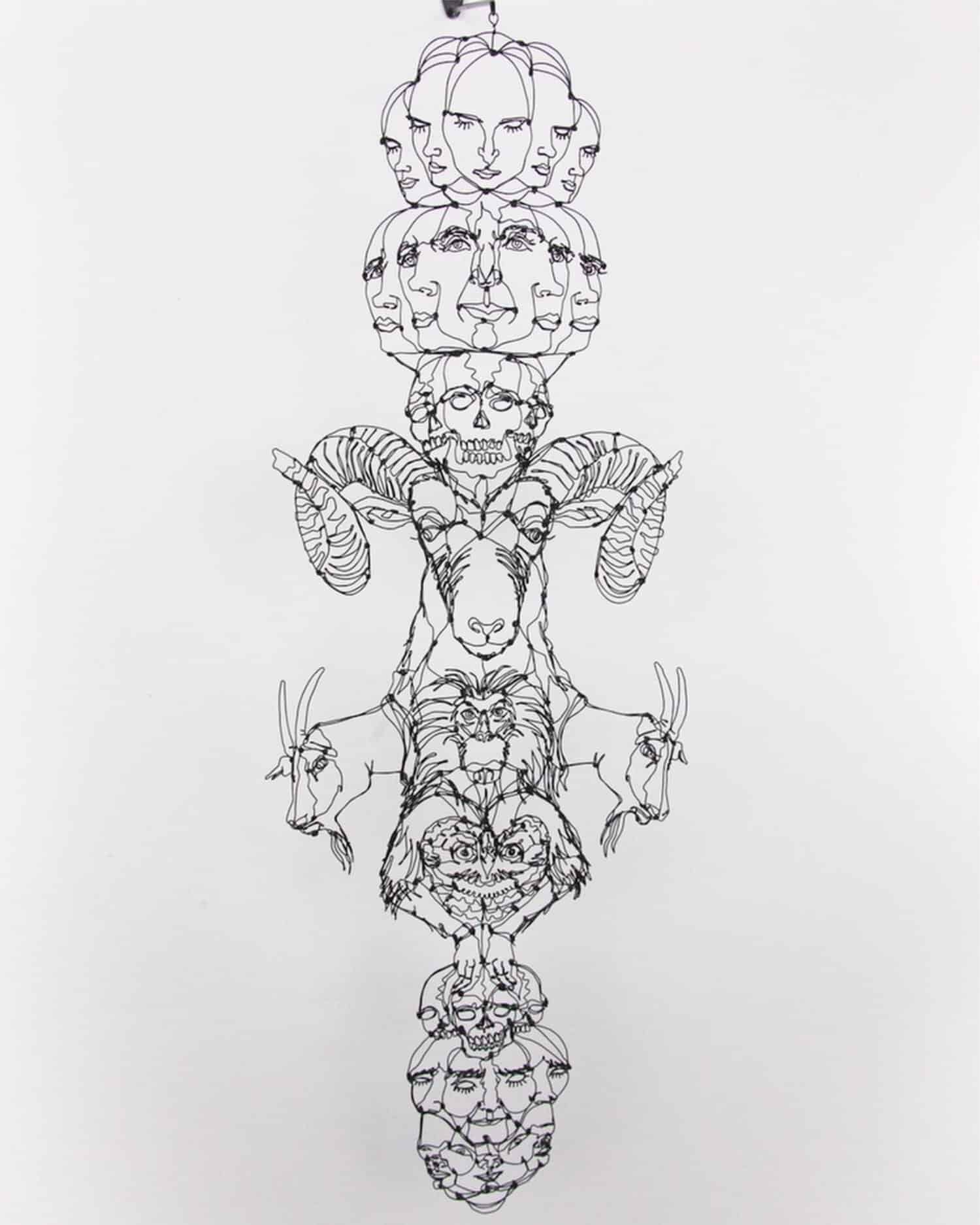 Intricate wire sculpture featuring faces, animals, and skulls symbolizing life and death.