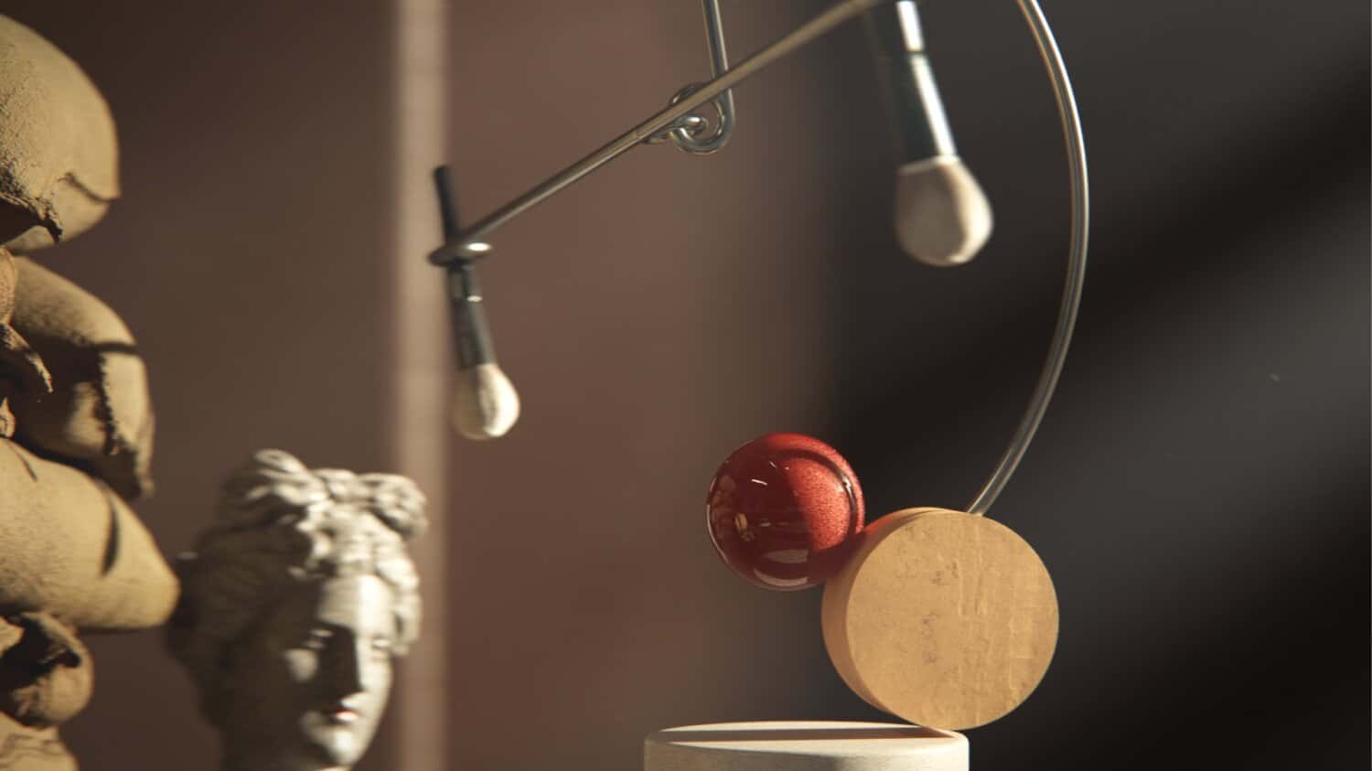Modern kinetic sculpture art piece featuring a rotating red sphere and circular elements.