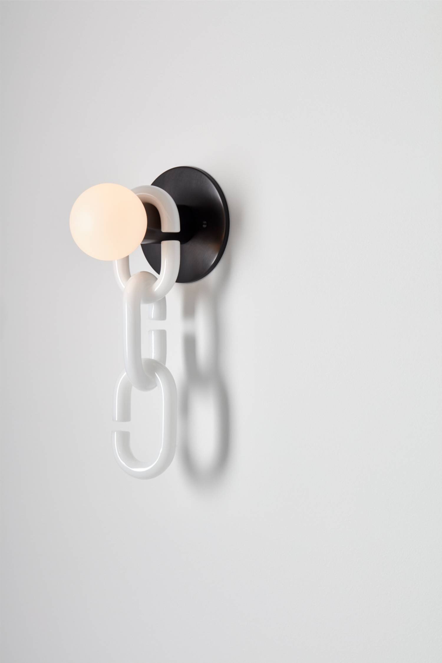 Minimalist modern wall sconce with white chain and glowing bulb, contemporary interior lighting design, visual atelier 8 style.
