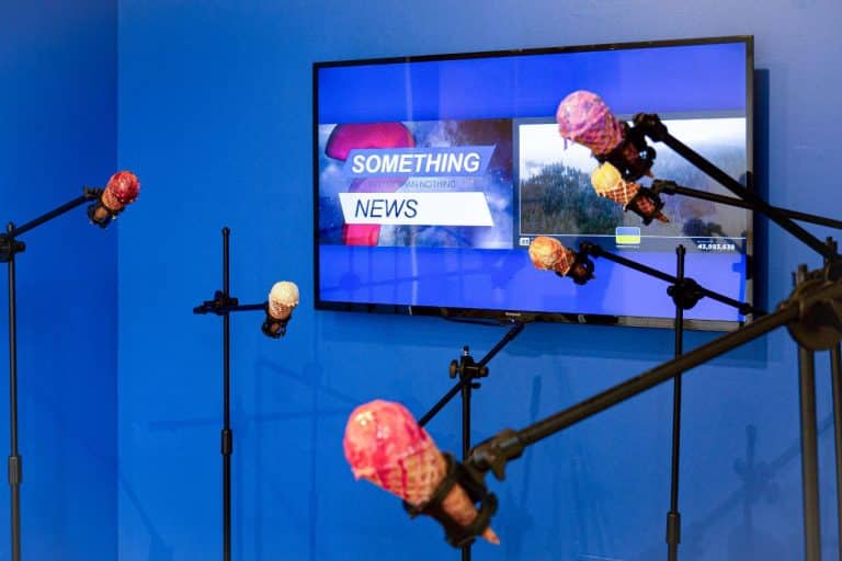 Ice Cream Discourse: A Multi-Sensory Innovative Installation by Hailing Liu Ice cream cone robot arms with microphone stands in front of a TV monitor at Visual Atelier 8.
