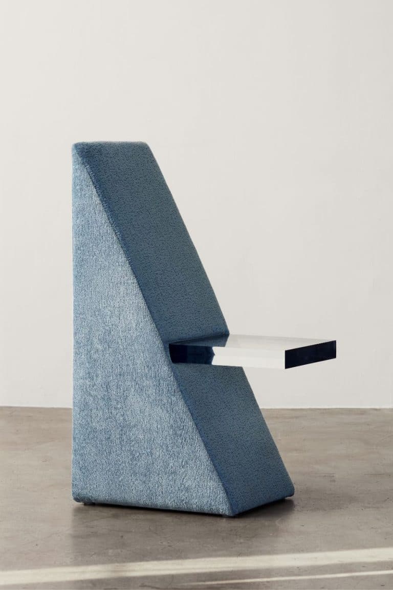 From: C's BLOC Collection: A Playful Fusion of Nostalgia and Sculptural Elegance Contemporary sculptural chair with textured blue fabric and sleek white floating seat.