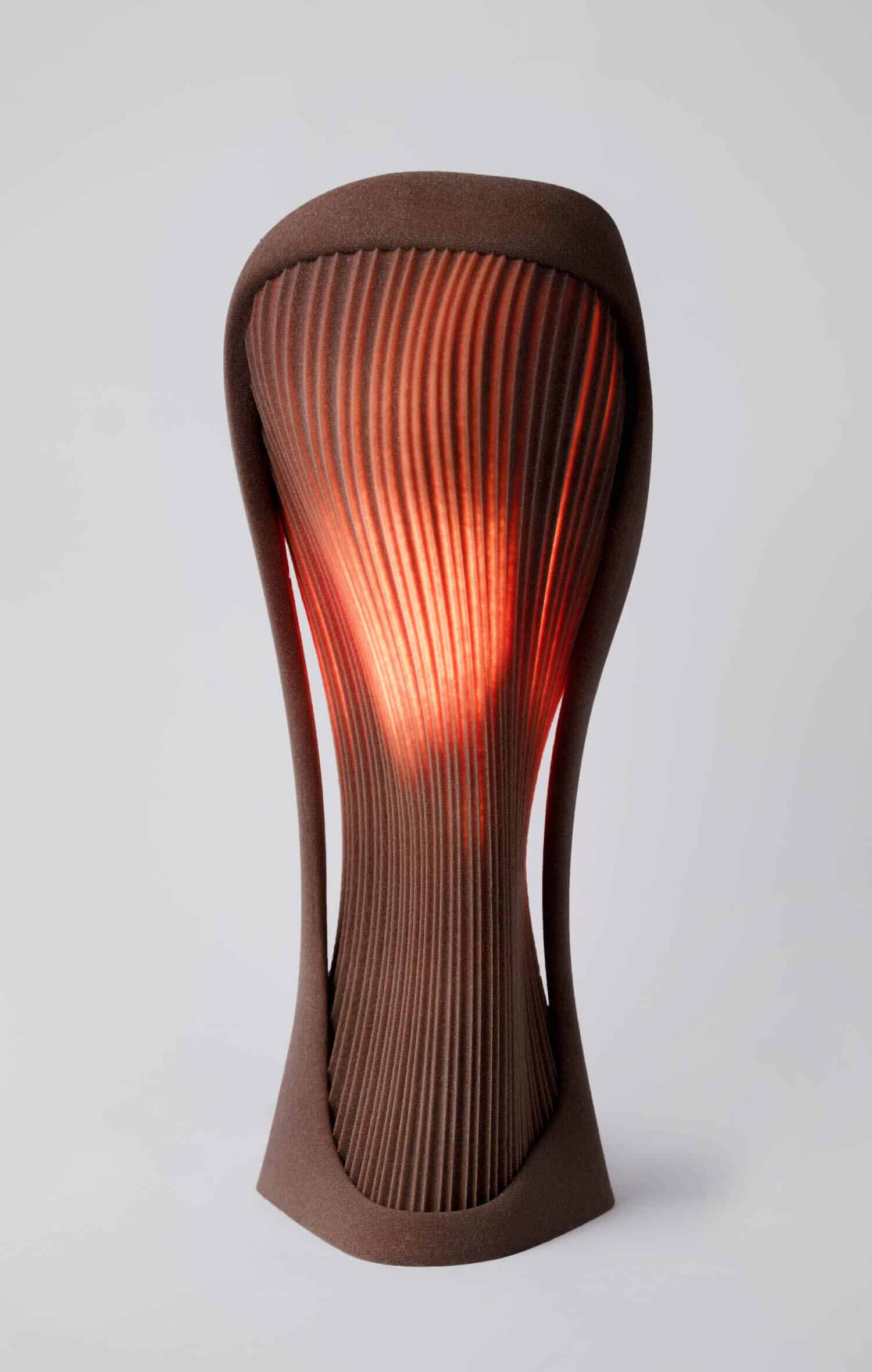 Sleek modern wooden table lamp with sculptural design and warm ambient lighting.