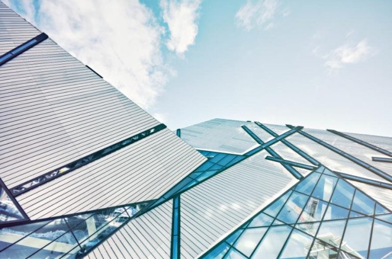 Architectural Glass in Modern Spaces: The Transparent Transition from Function to Art Futuristic glass and metal building architecture with reflective surfaces and geometric design.