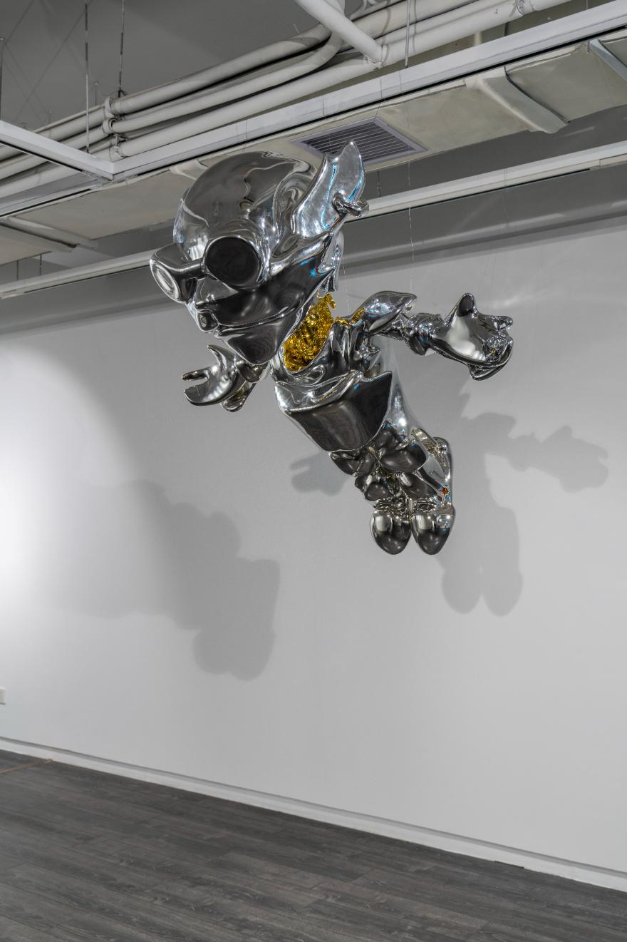 Shiny metallic sculpture of a stylized animal figure hanging from ceiling at Visual Atelier 8.