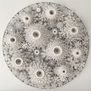 Intricate white paper cut art featuring detailed floral and geometric patterns.