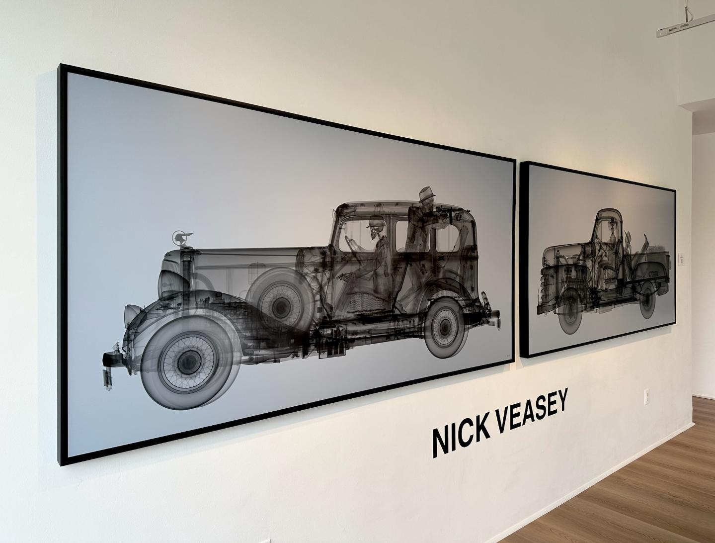 Vintage car blueprint artwork by Nick Veasey displayed at Visual Atelier 8, showcasing innovative photography art in a modern gallery setting.