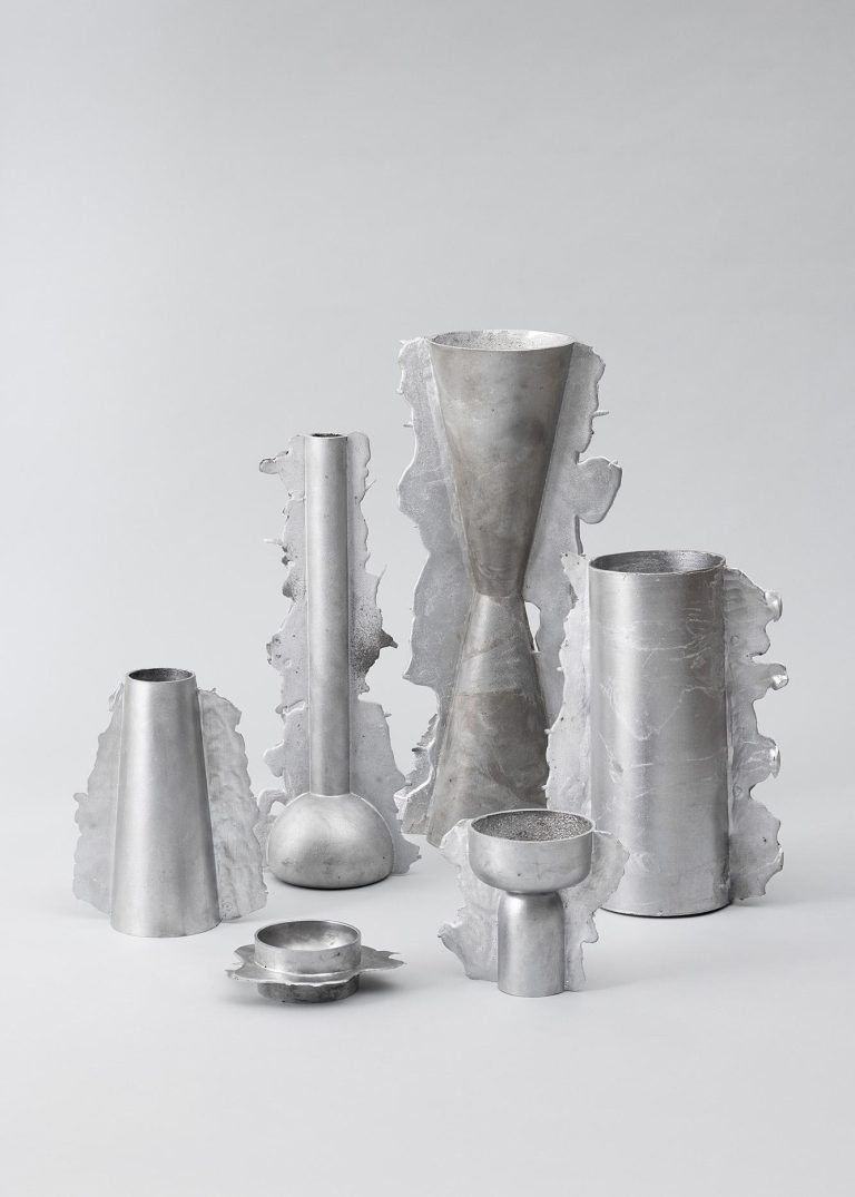The authentic craftsmanship behind Anna Zimmermann's 'Vessels of Imperfection' Contemporary silver metal vases and bowls with textured edges, minimalist design on a plain background.