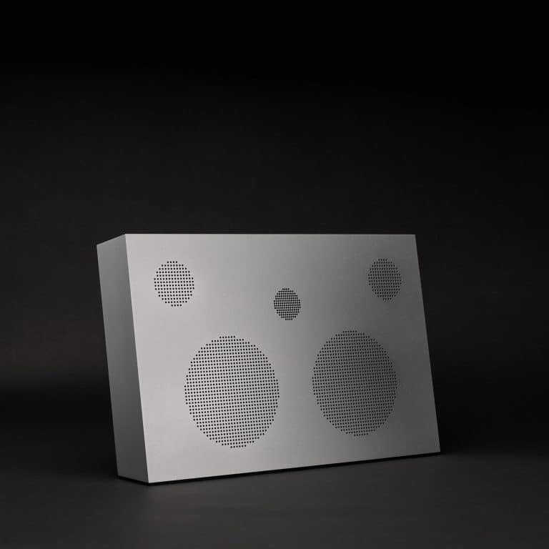 Perforated metallic speaker panel on black background, modern audio system design.
