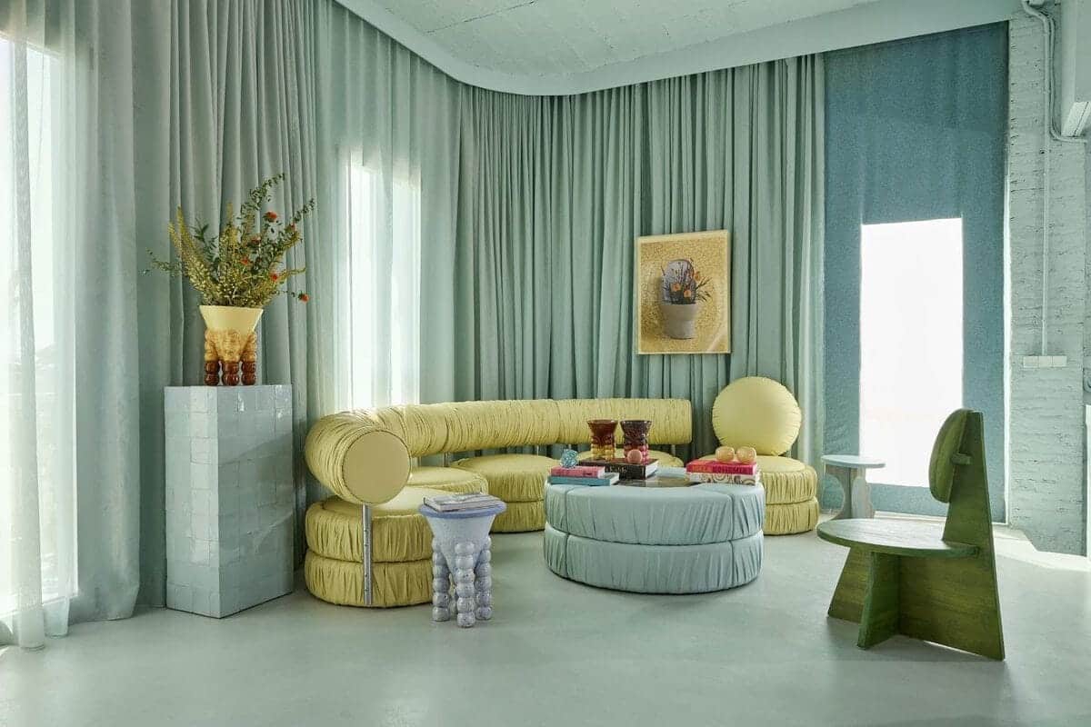 Colorful modern living room with eclectic furniture, light blue accents, and decorative elements.