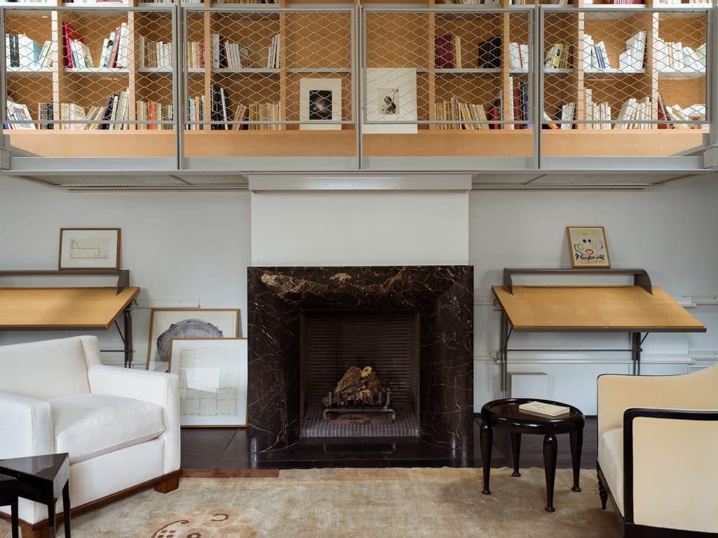 Modern living room with cozy fireplace, bookshelves, and elegant furniture, showcasing contemporary interior design.