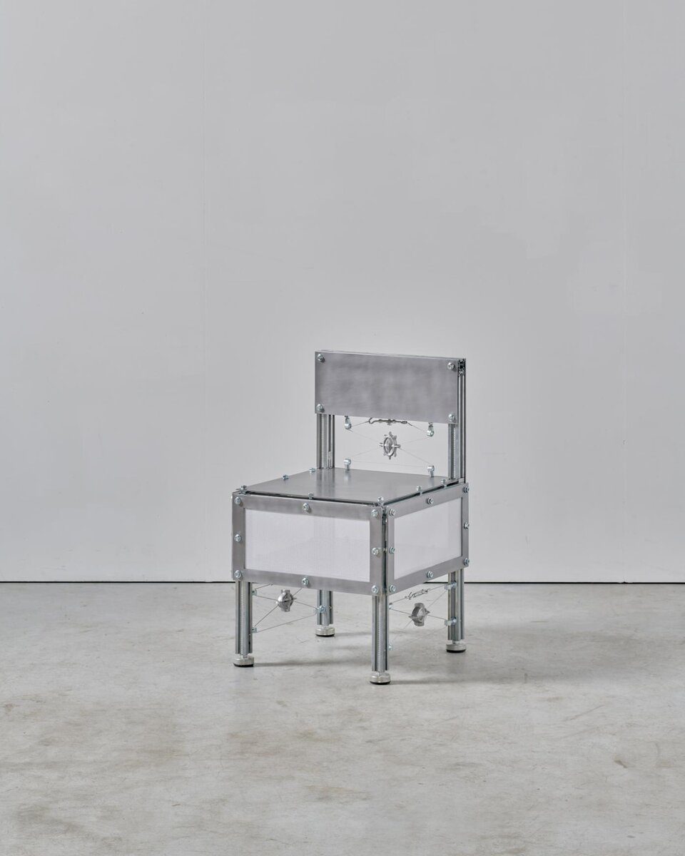 Metal chair sculpture with industrial design, minimalist aesthetic, and sleek aluminum finish.