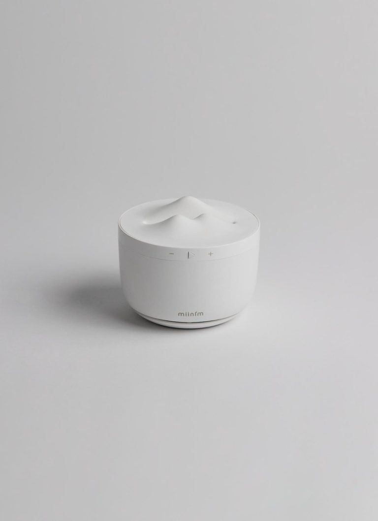 Meditation audio player inspired by Zen aesthetics Sleek white ultrasonic essential oil diffuser on light gray background.