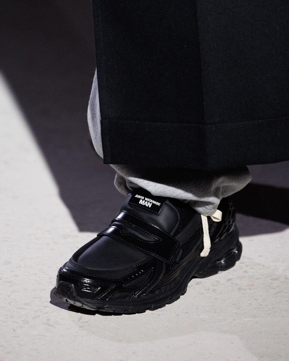 Nike black sneaker with strap and white text, casual streetwear footwear.