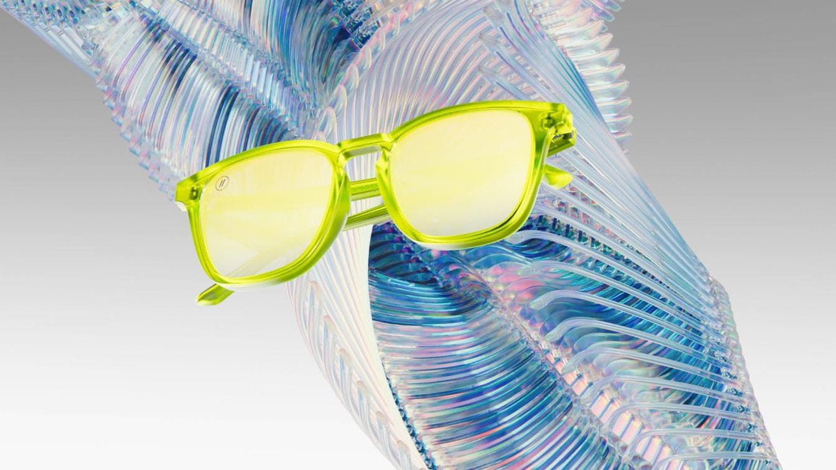 Bright yellow sunglasses resting on a colorful iridescent leaf, showcasing modern eyewear design and vibrant accessories.