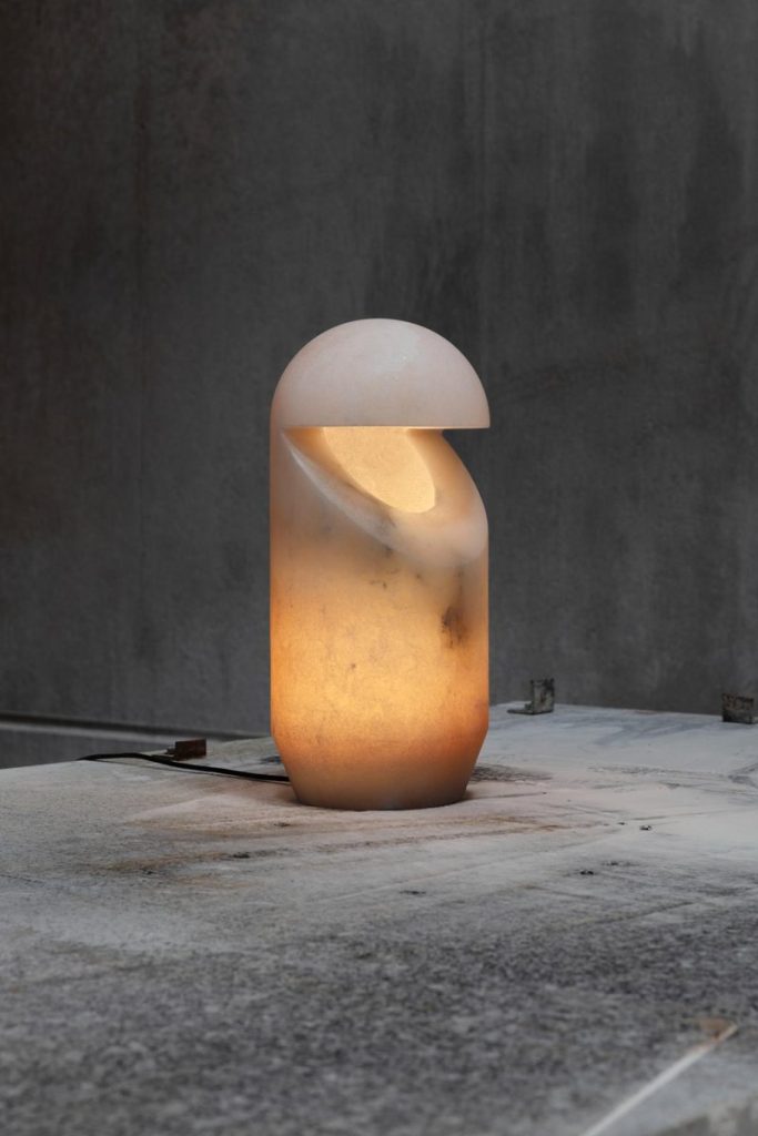 Sculptural ceramic table lamp with modern minimalist design and warm ambient lighting.
