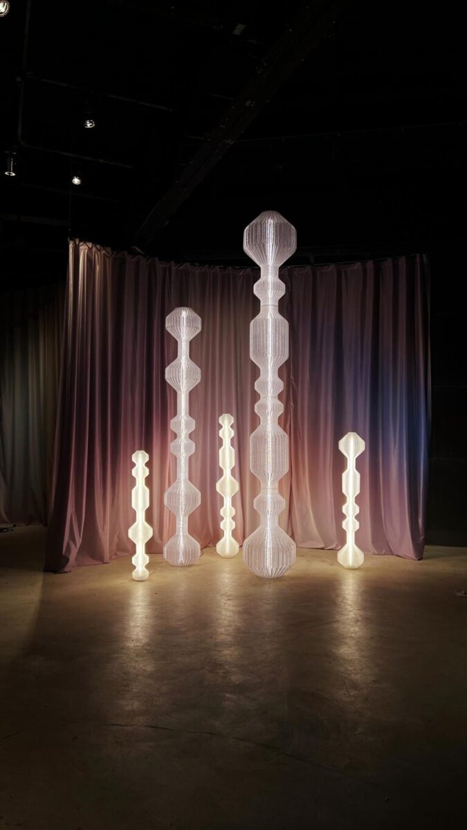 Monumenta by Lucas Zito: Sustainable, customizable 3D-printed lighting Contemporary illuminated sculptures with geometric shapes on a dimly lit exhibition space.