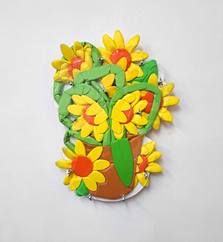 The art of suspended moments in Ant Hamlyn's sculptural work Vibrant inflatable sunflower wall art with bright yellow petals and green leaves in a colorful flowerpot.