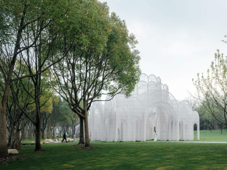 Emerald Screen Pergola a modern revival of classical Chinese garden design Elegant white architectural structure amidst lush green park with trees, modern design, scenic outdoor space, and landscaping.