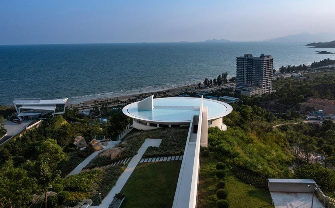 Modern seaside luxury hotel with infinity pool and scenic ocean views in tropical destination.
