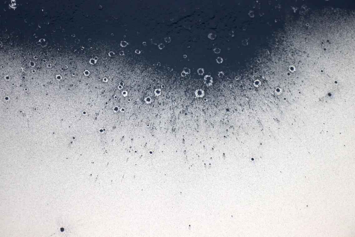Vibrant blue and black abstract watercolor paint splashes on textured paper.