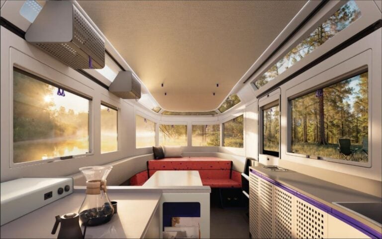 Lightship AE.1 Cosmos Edition, the world's first all-electric travel trailer Cozy mobile tiny house interior with large windows and scenic forest views, modern design and compact living space.