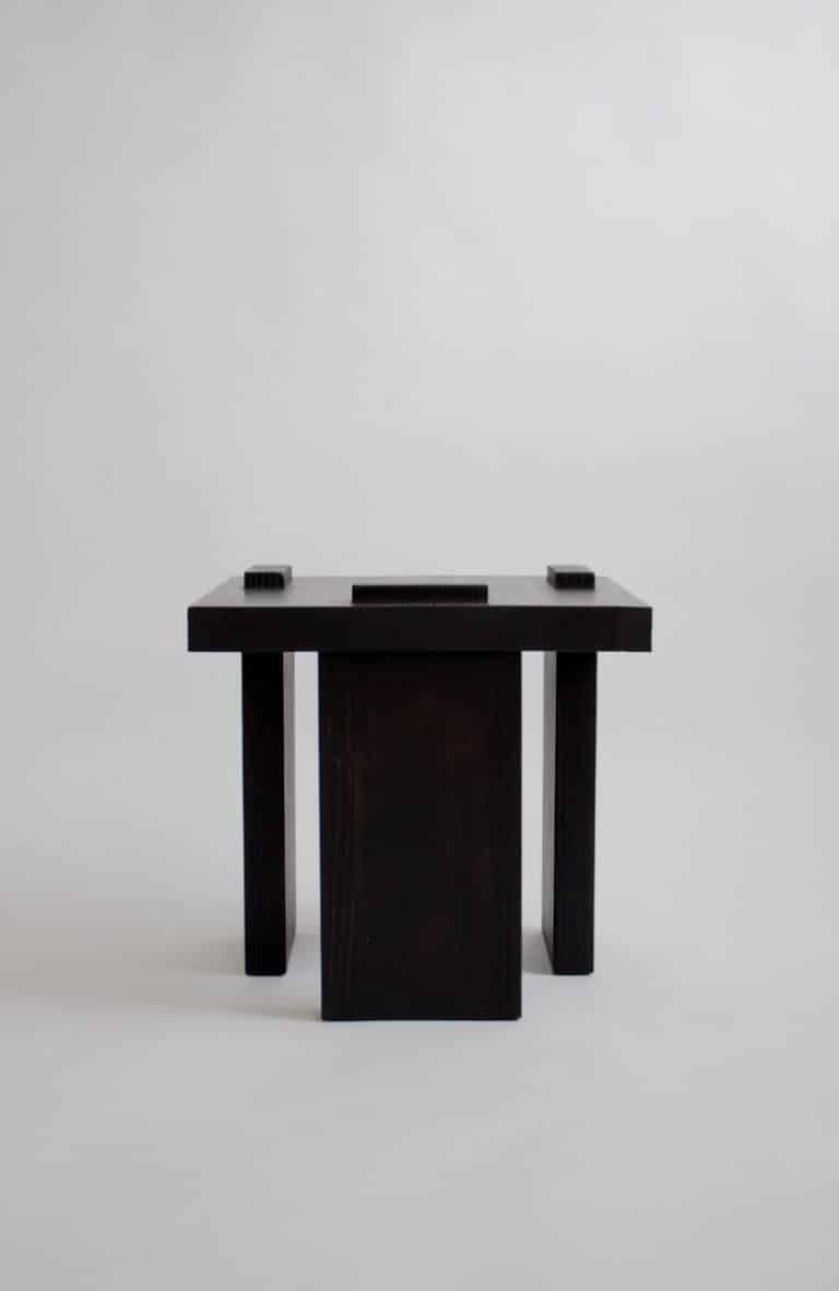 ITOORABA by Sizar Alexis: A geometric tribute to heritage and modern design Minimalist black wooden table against a plain white background for modern interior decor.