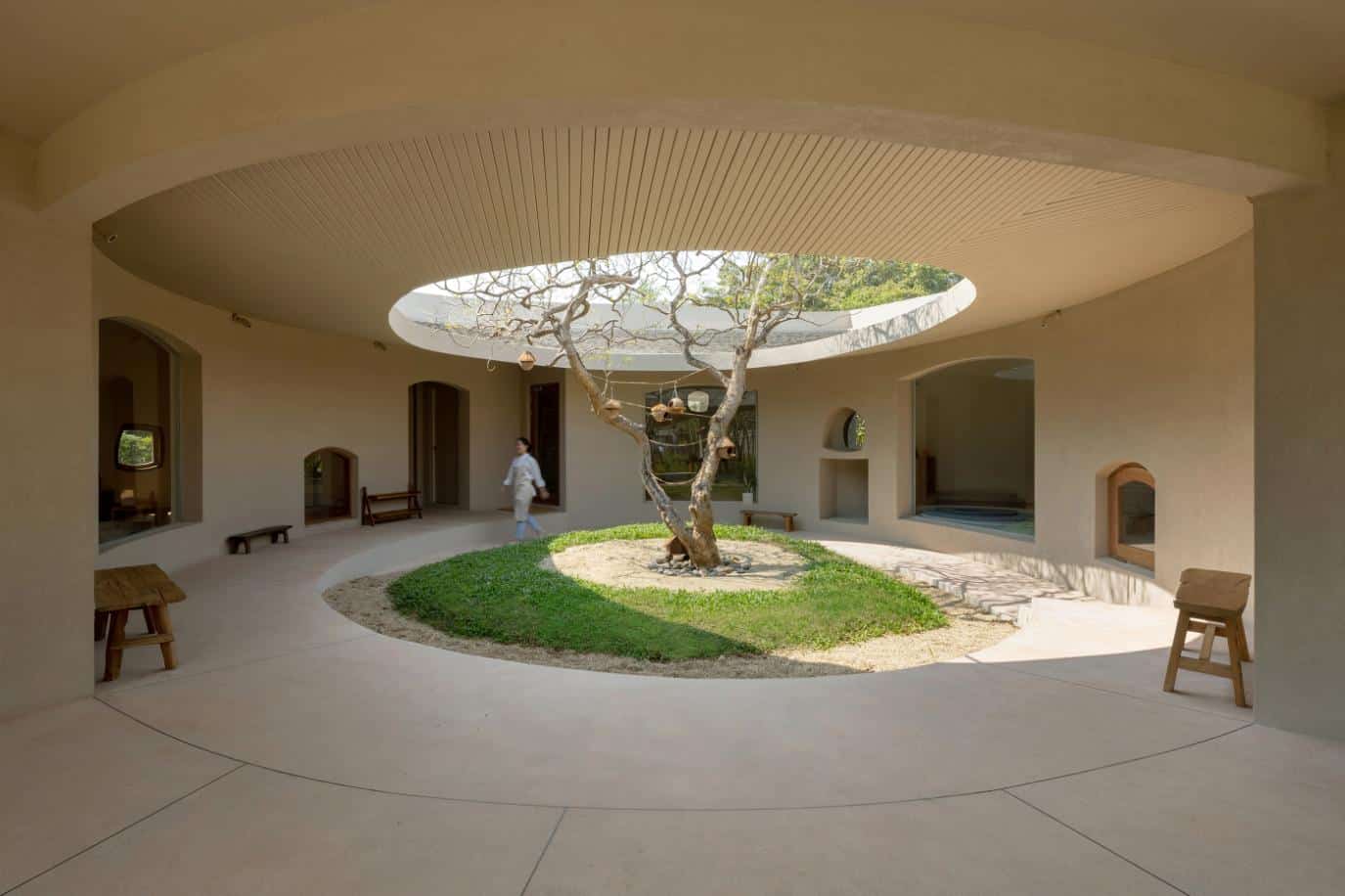 Modern circular courtyard with central tree and minimalist design by Visual Atelier 8.