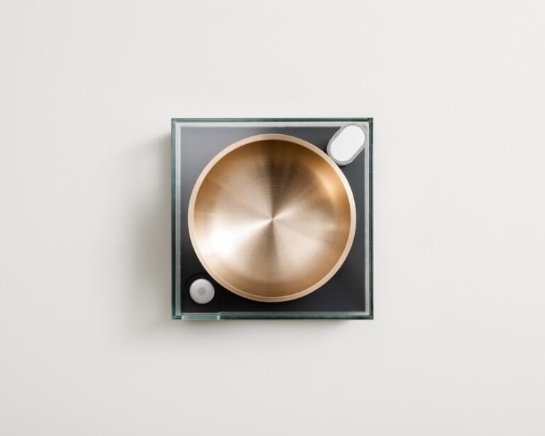 Sonic Heirloom: Transforming sound into a vessel for memory preservation Sleek modern turntable with a metallic gold platter on a minimalist square base.