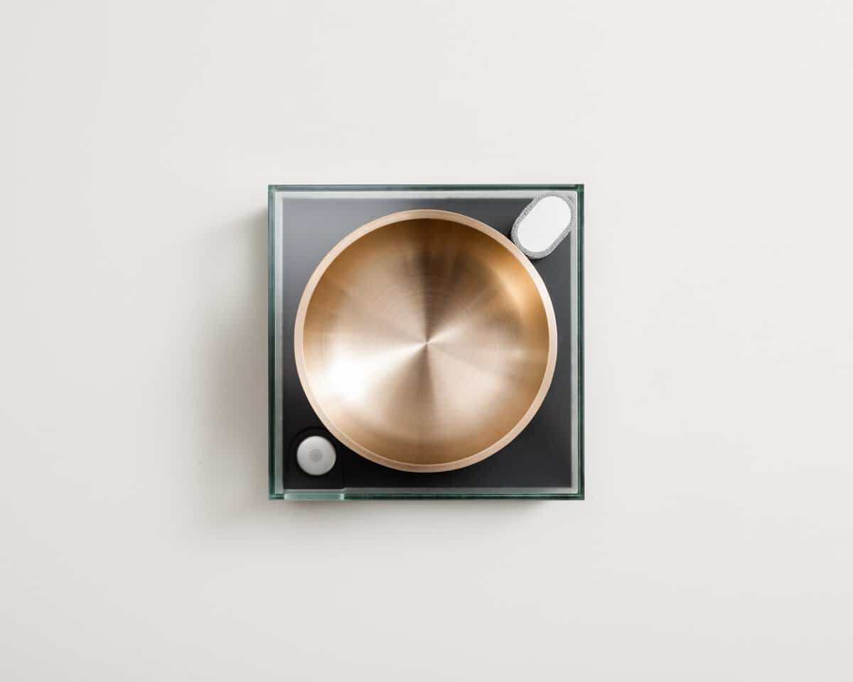 Sleek modern turntable with a metallic gold platter on a minimalist square base.